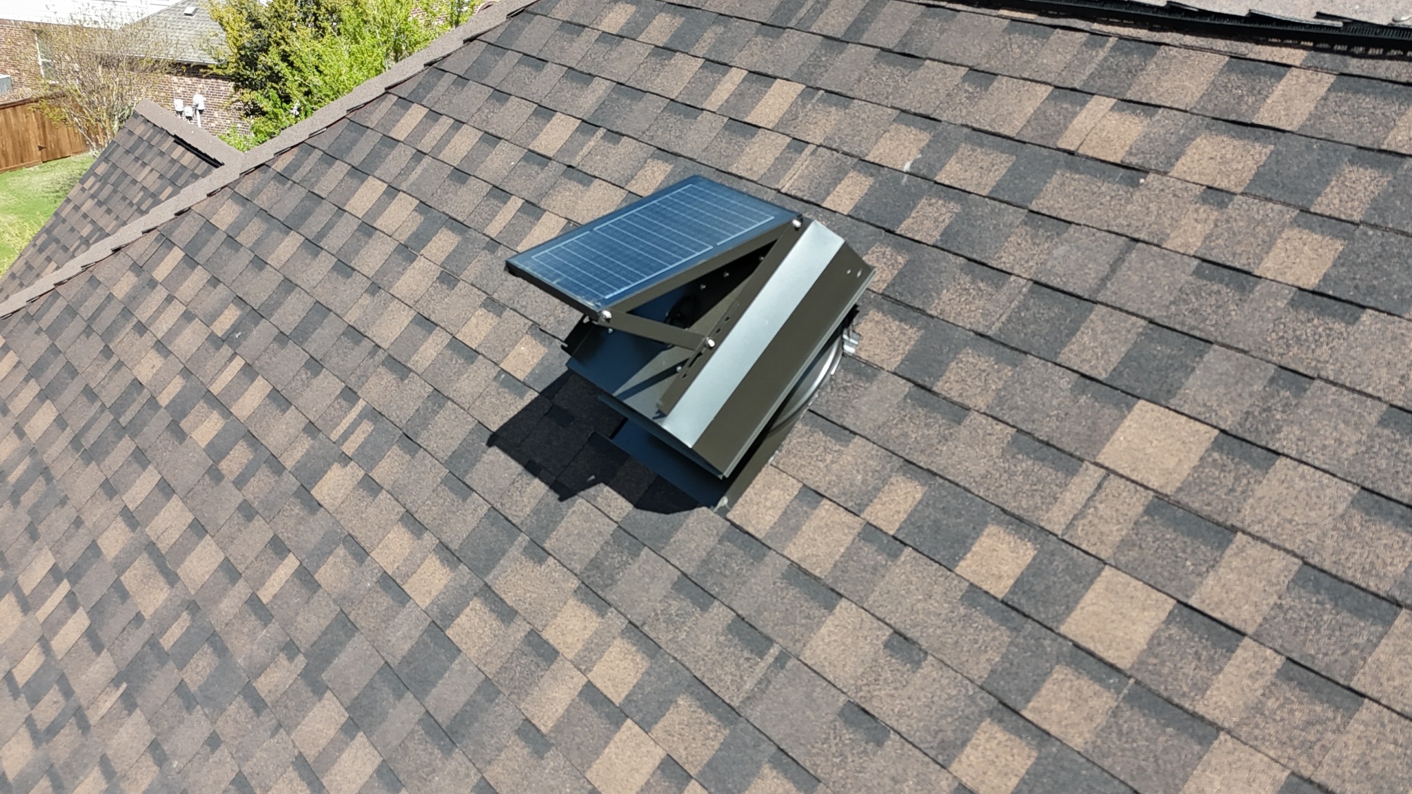 Solar attic fan on brown architectural shingles
